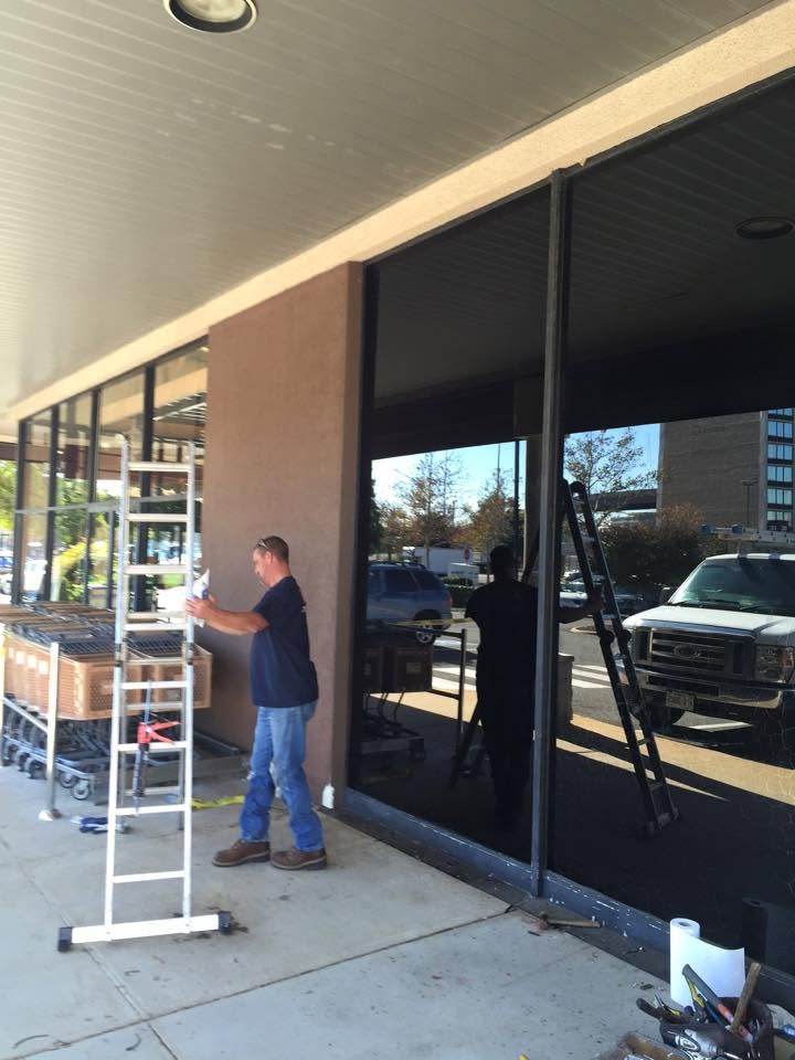 American Screen & Glass technician installing large storefront glass
