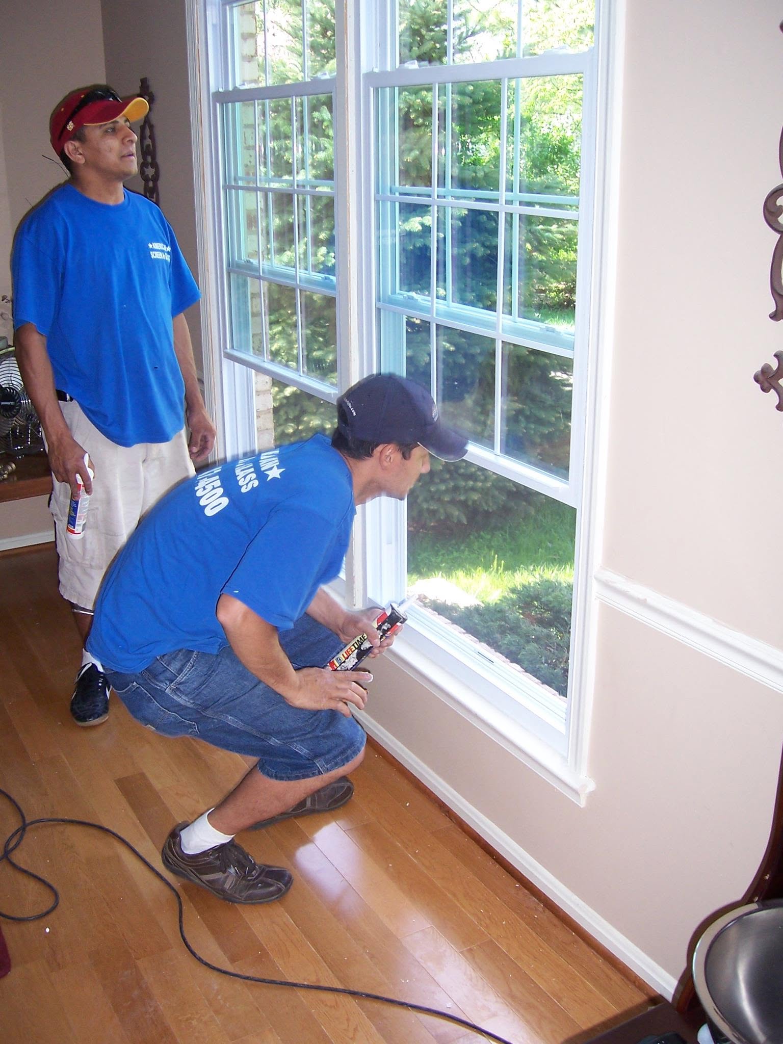 Two American Screen & Glass technicians working on a window in the early days