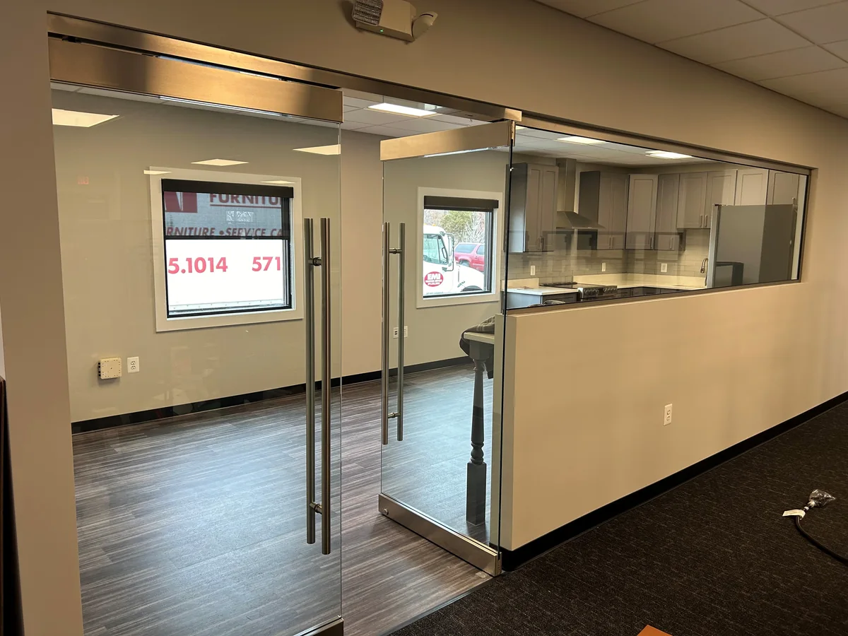 Glass office entrance with long pull handles and a glazed partition.