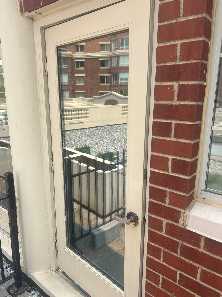 Full-view storm door with a light frame at a brick entry