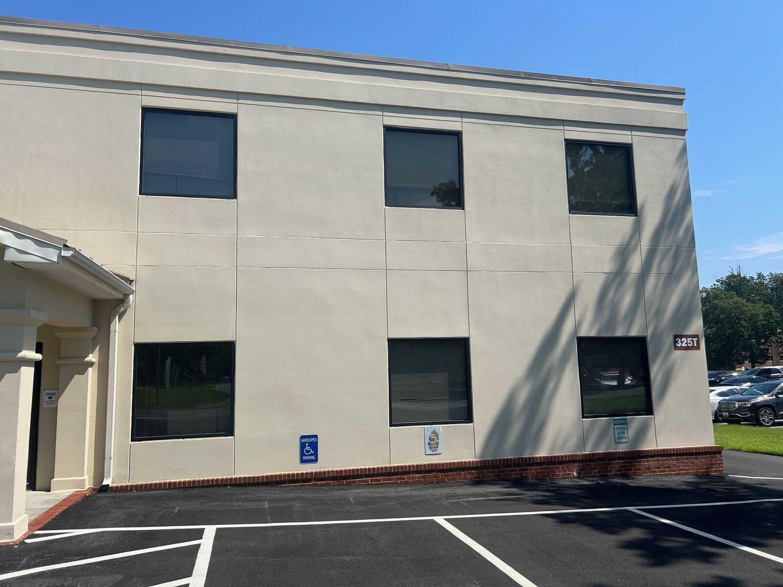 A two-story commercial office building with rows of dark-framed windows