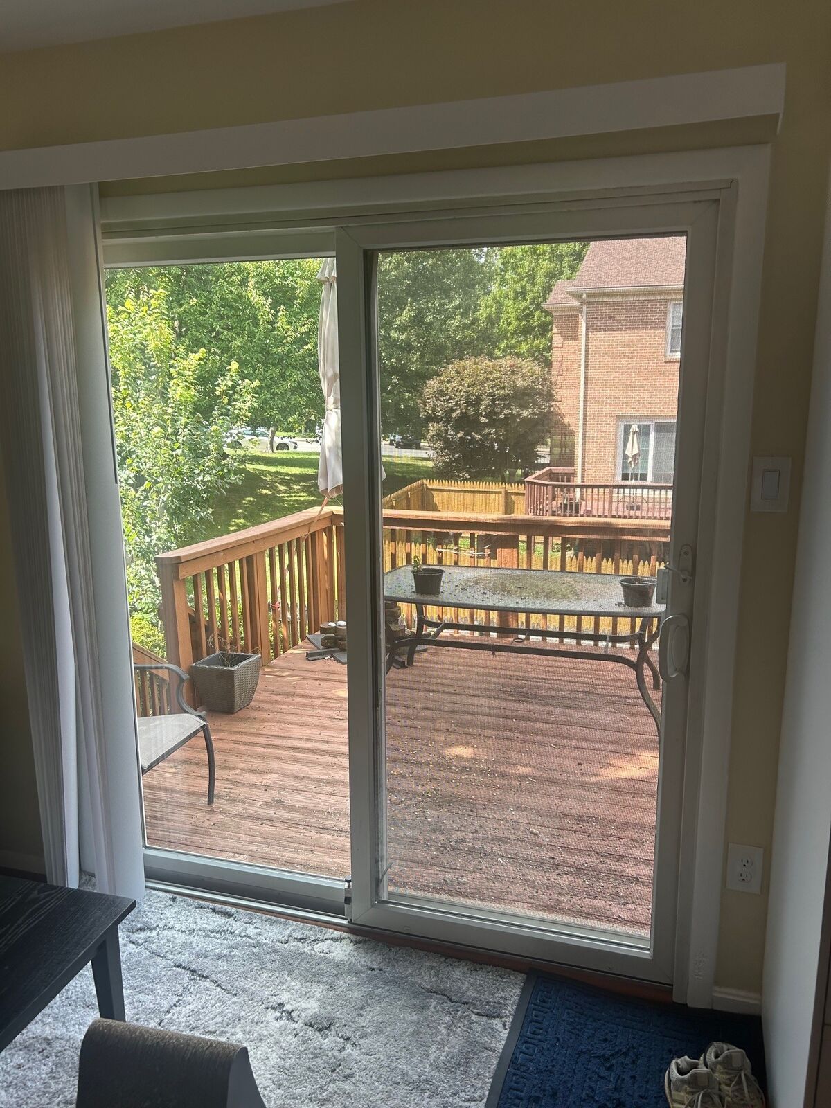 A white sliding patio door opening onto a wood deck