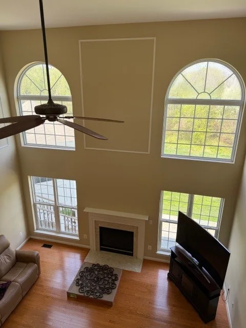 Tall arched windows light a two-story living room.
