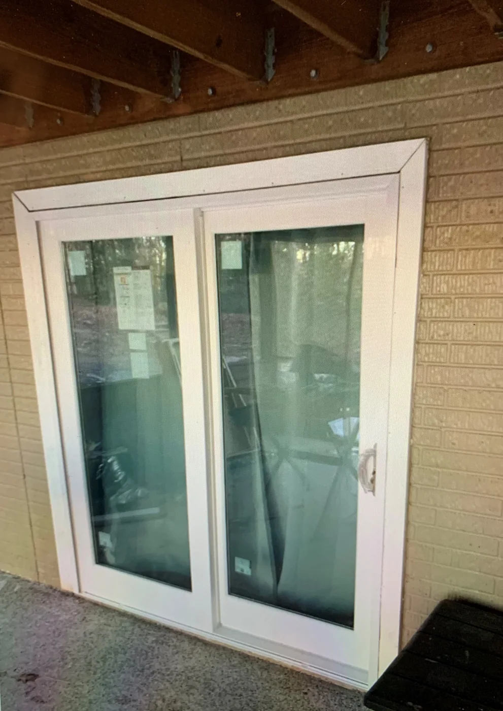 White sliding patio door in a brick wall.