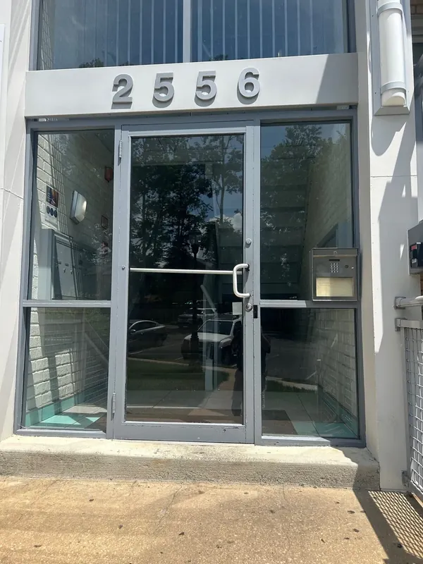 A metal-framed glass entry has sidelights and a transom.