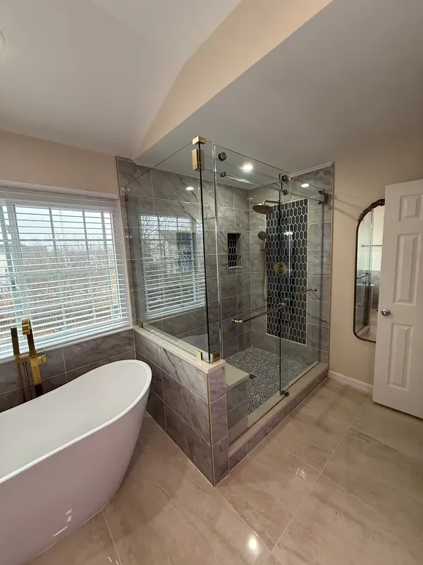 Corner shower beside freestanding bathtub.