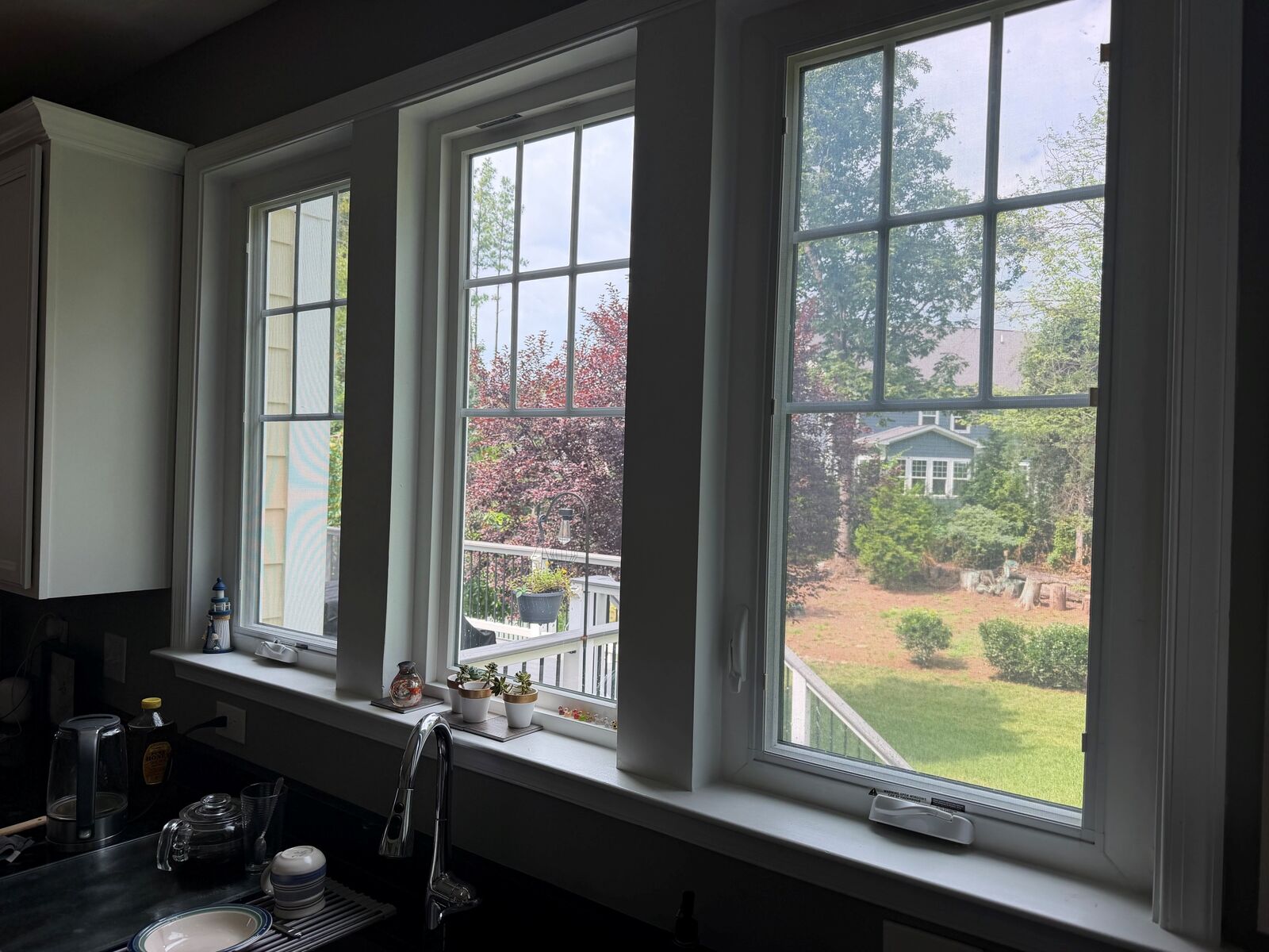 Three divided-pane windows with grids above a kitchen counter