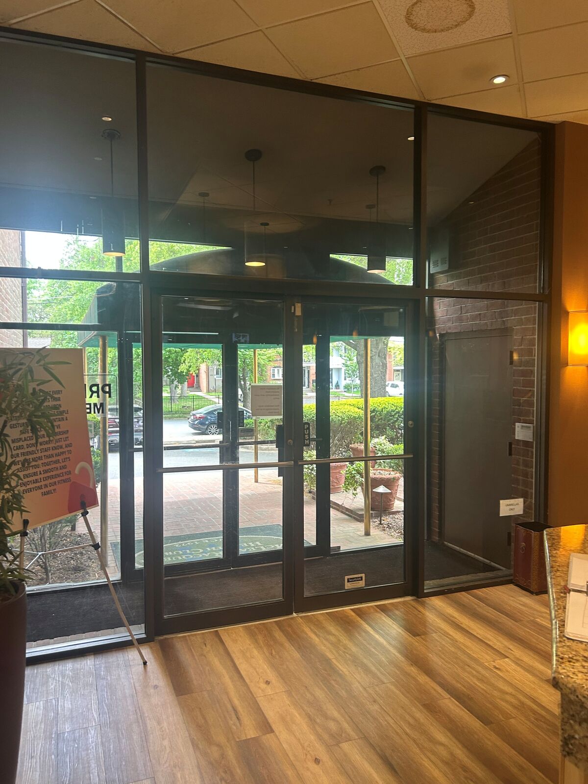 A dark-framed commercial storefront glass entry seen from inside a finished lobby