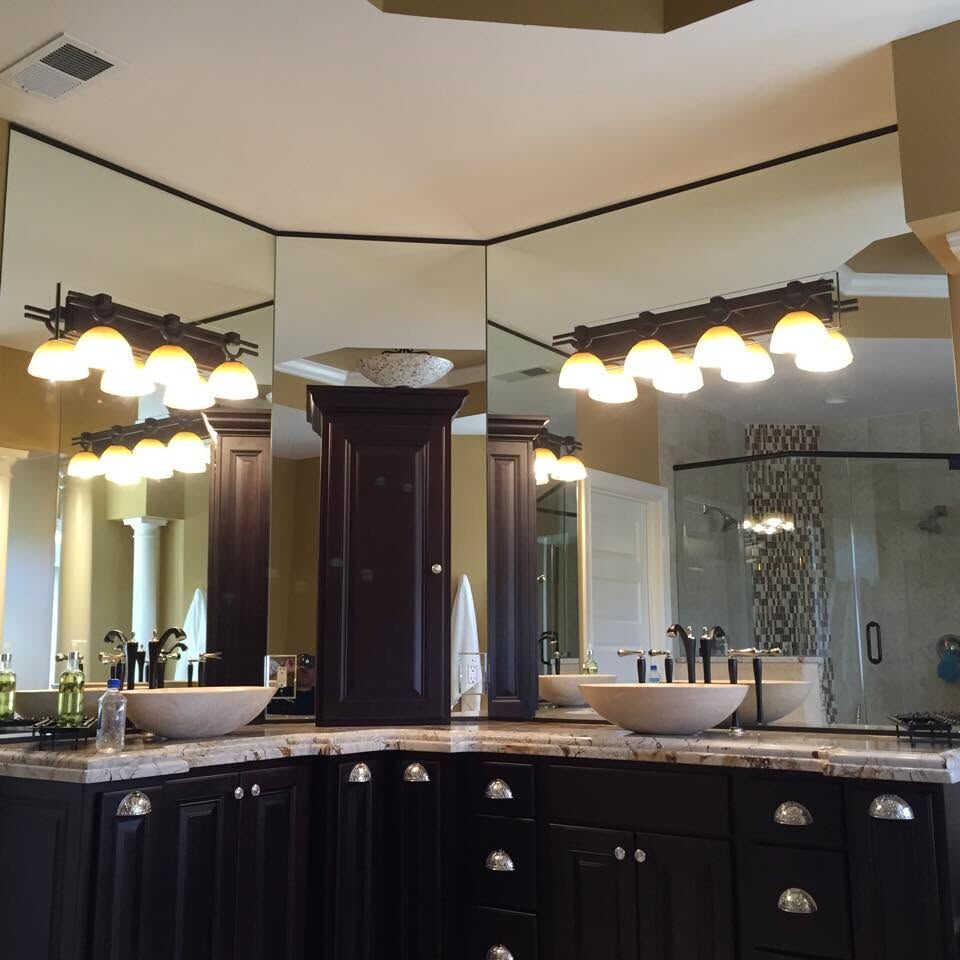 Custom mirrors over a double bathroom vanity, meeting at an angle in the corner