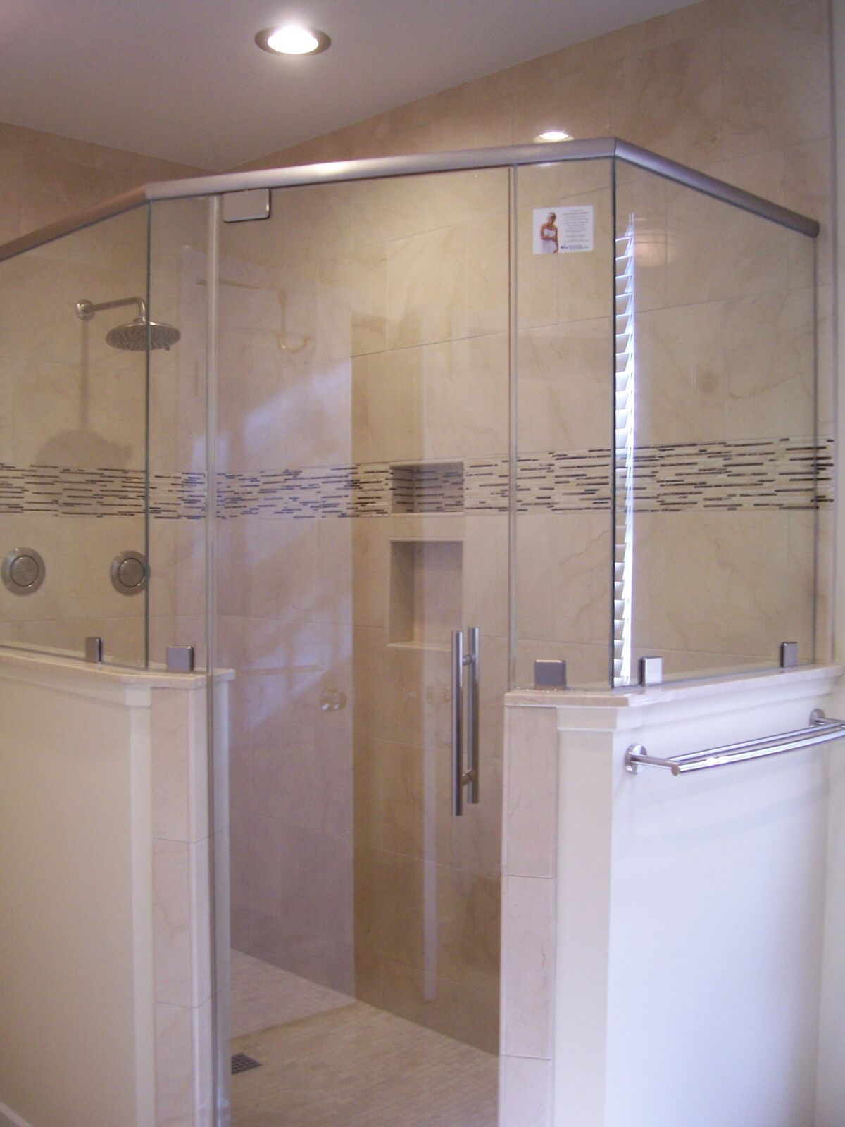 An angled glass shower enclosure with patterned privacy bands across the glass
