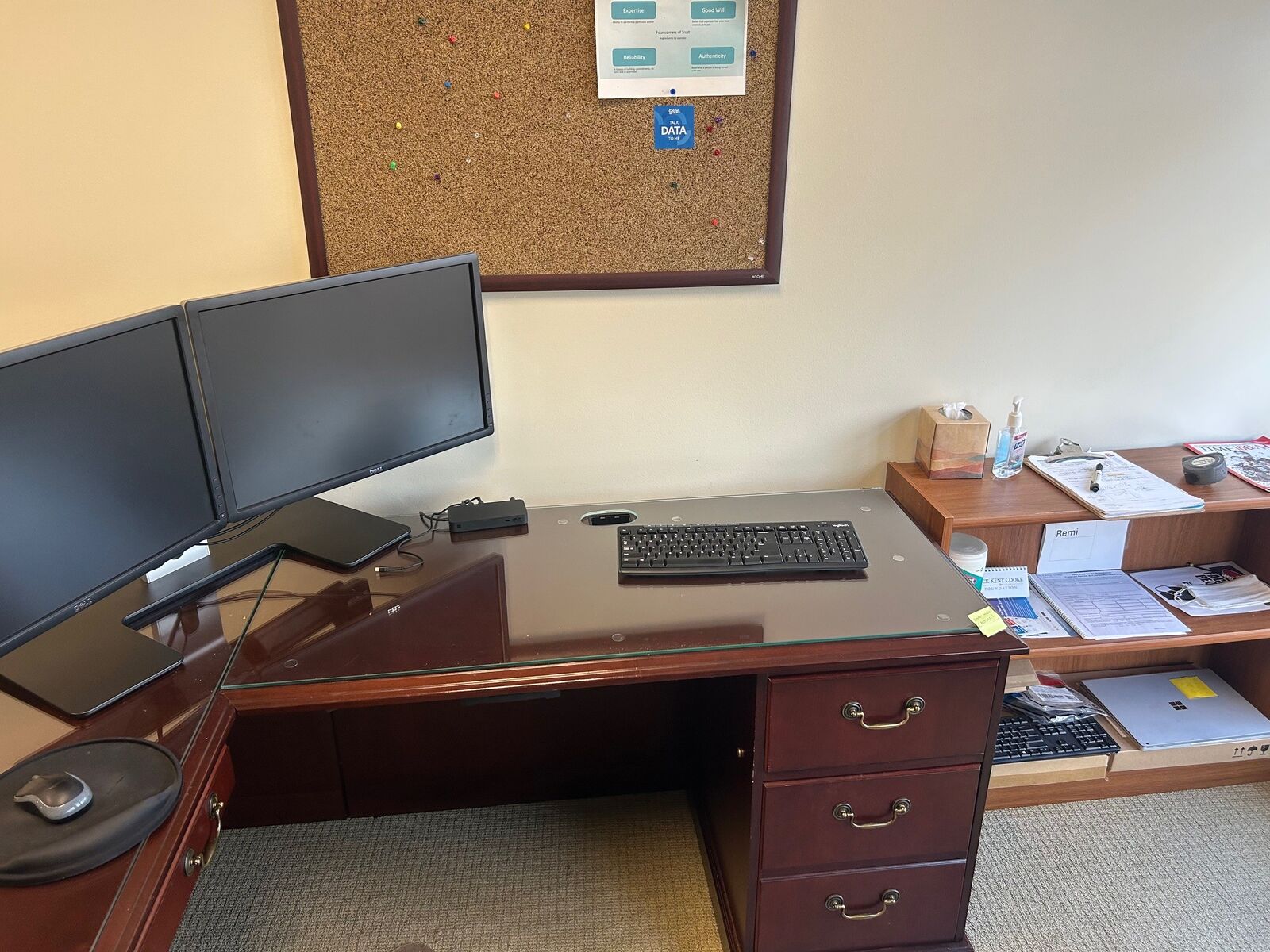 A clear glass protective top covering a wood office desk