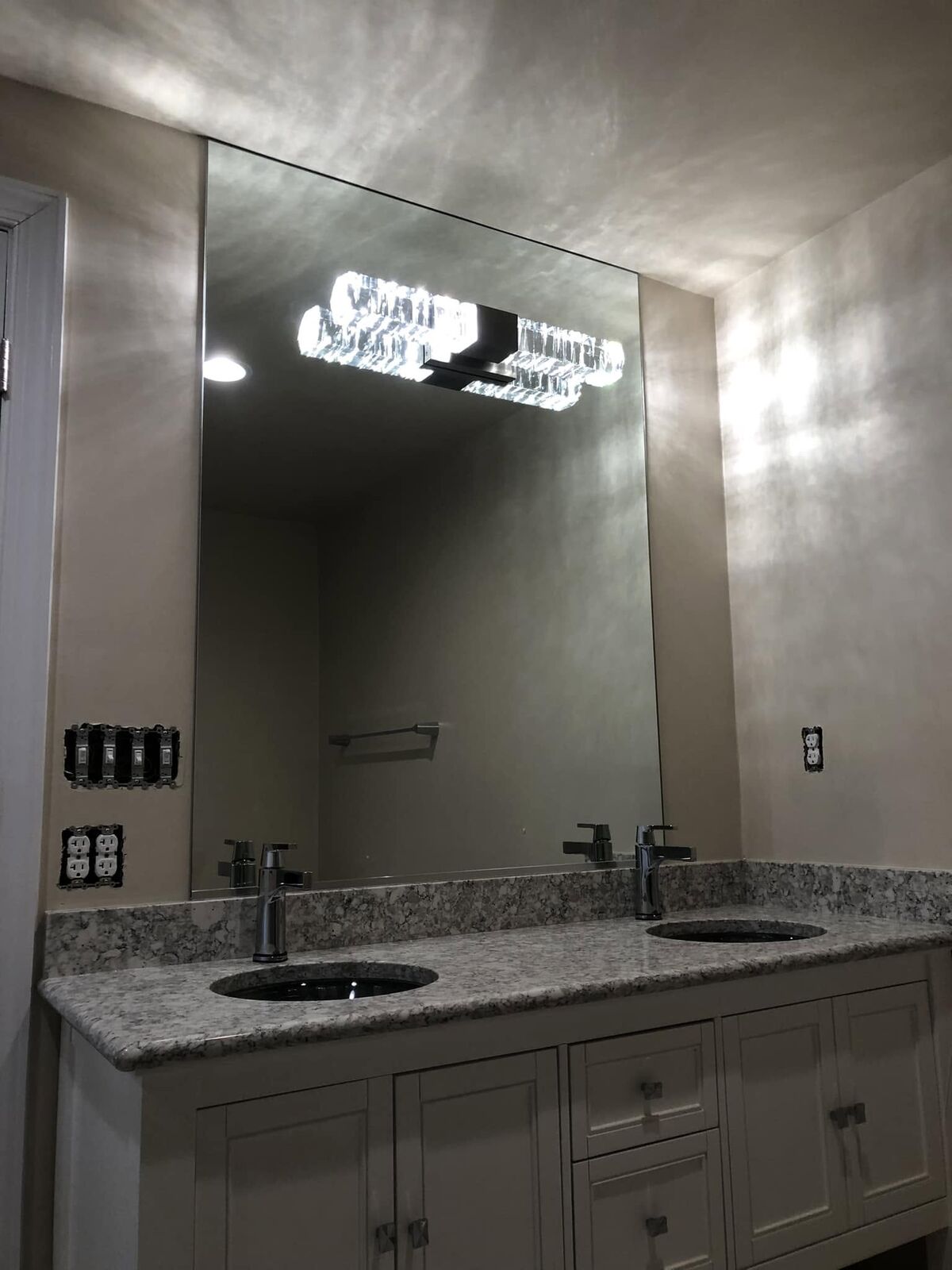 A large custom mirror over a double bathroom vanity