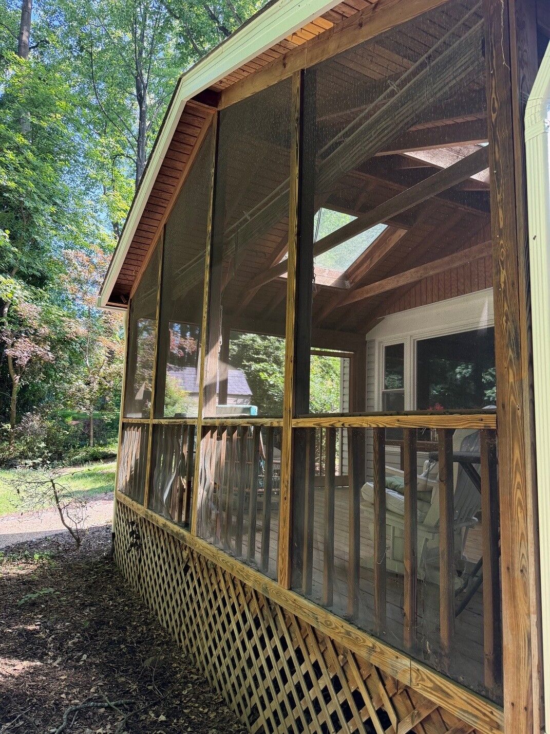 A wood-framed screened porch side with a lattice base