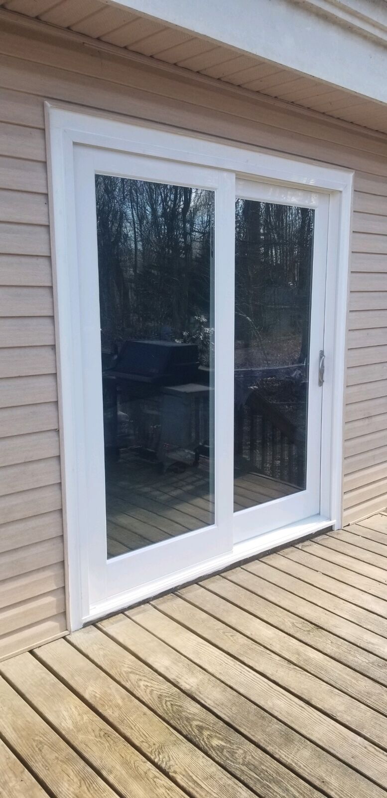 A white sliding patio door opening onto a wood deck