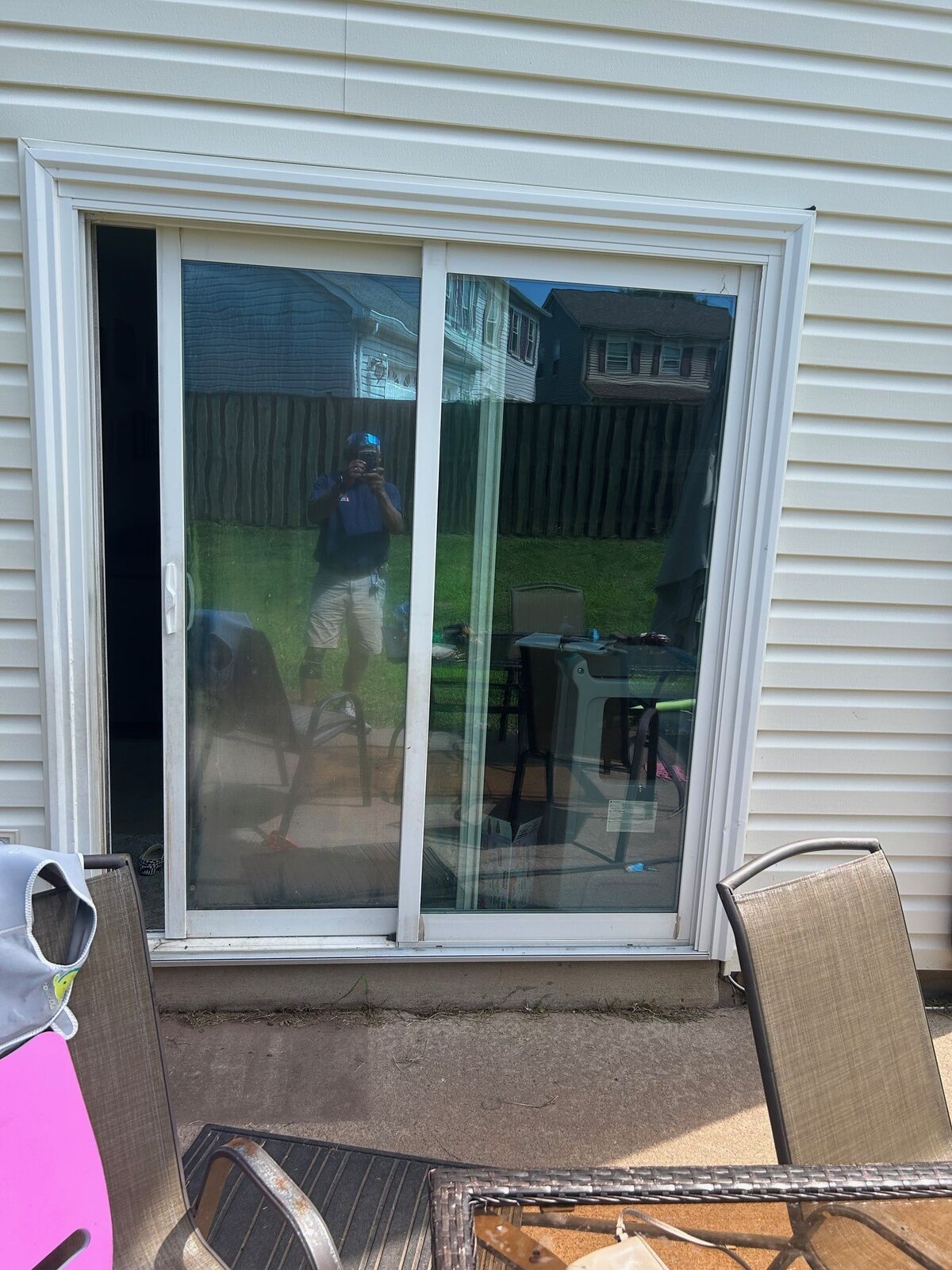 A white sliding patio door seen from outside on a wood deck