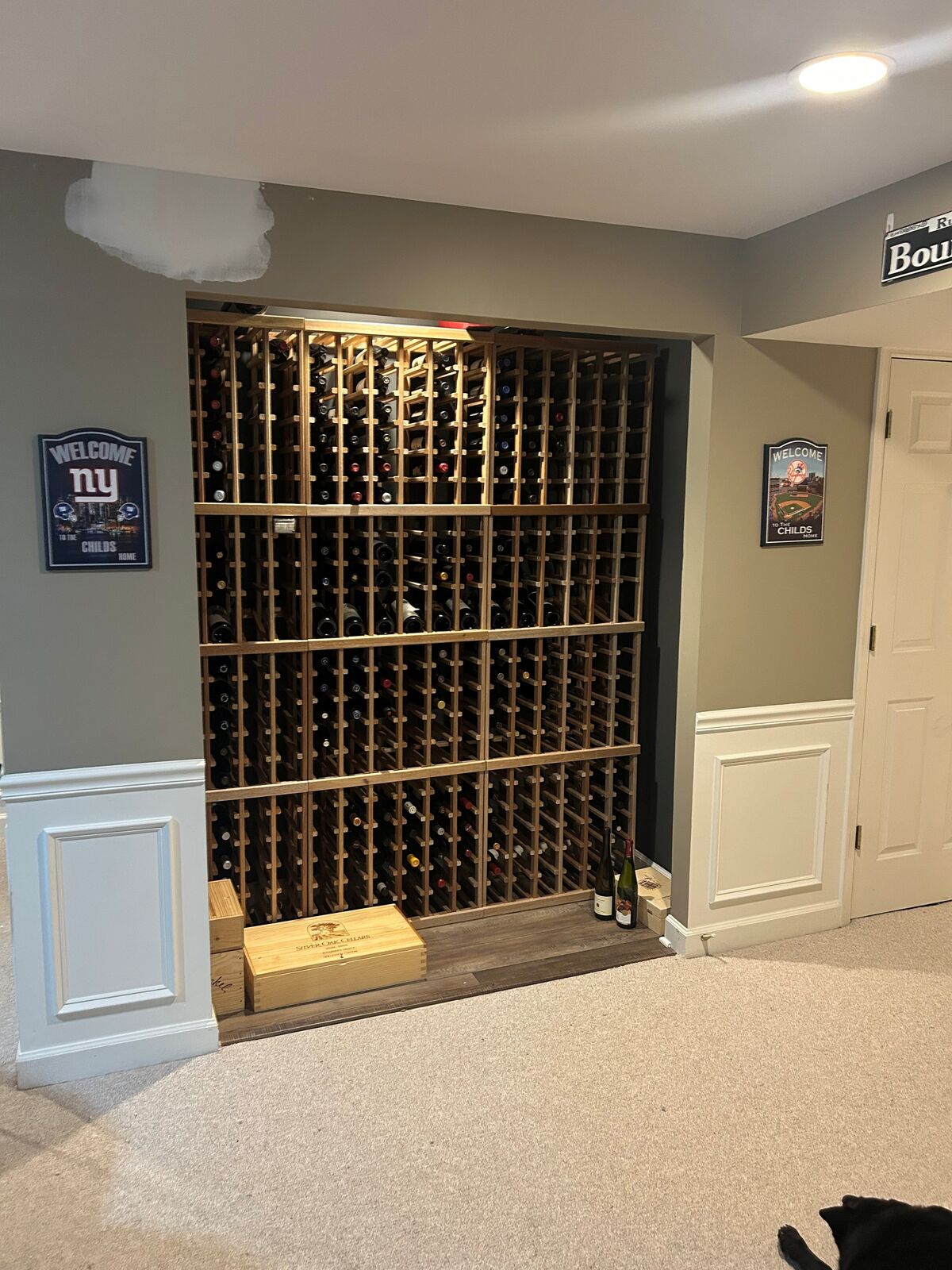 A glass-fronted wine storage display with bottles on racks behind the glass
